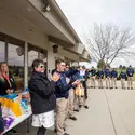 Students applaud as a raffle winners name is drawn from a bag during a charity golf tournament.