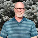 Greg Wilson standing in front of trees