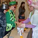 Students handing helping kids with Halloween craft