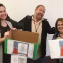 Employees holding Holiday Food Donation Drive boxes
