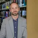 Jaren Watson leaning against bookshelf 