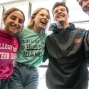 Students with arms around each other smiling and laughing