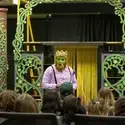 Actor on stage in makeup and crown