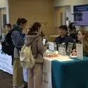 Students speaking with staff at a table