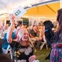 Woman holding up paddle to bid