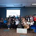 Group of people cheering in front of projector screen