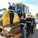Heavy Equipment Technician students standing in front of bulldozer