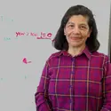 Teresa Tarifa de Yensen in front of a white board at the Tutoring Center