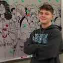Caleb Chereji standing in front of his whiteboard mural