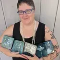 Jessie Swimeley holding pieces of her art