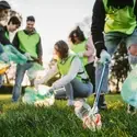 Students volunteer in a park by picking up trash.