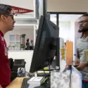 Staff assisting a student at One Stop Student Services.
