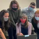 Psychology students and professors working together at a laptop