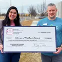 CWI employees, Heather Grayson and Dallas Hulsey, holding check from S.E.E.4VETS