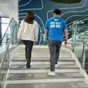 Two people walking up staircase