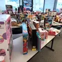 Hundreds of new toys in boxes are pictured on top of tables. 