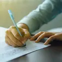 Image is a close-up of a student taking an exam.