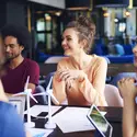 A group of smiling coworks collaborate at a table.