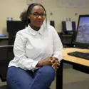 Viviane Akingeneye sitting at computer desk in Tutoring Center