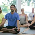 Class of yoga students seated with their eyes closed