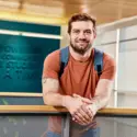 Student wearing a backpack smiling at the camera