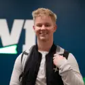 student smiling at the camera wearing a backpack