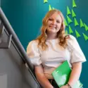 Student on campus holding a notebook