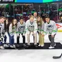 People wearing CWI hockey jerseys get ready to drop the puck on the ice during a hockey game.