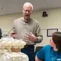 A professor teaches students about engineering using a model.