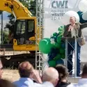 A speaker addresses an audience at a groundbreaking ceremony.
