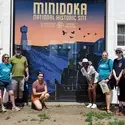 International Club members posing for a photo at the Minidoka National Historic Site sign
