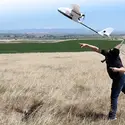 Student launching a drone in the air