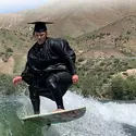 Tara Wright wake surfing at Lucky Peak in her cap and gown