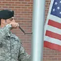 Serviceman reaching the flag