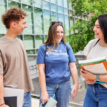 students standing in a group talking outside a campus building