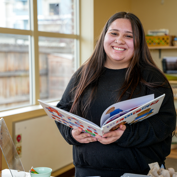 Alexus Hill reads a book in the middle of a classroom