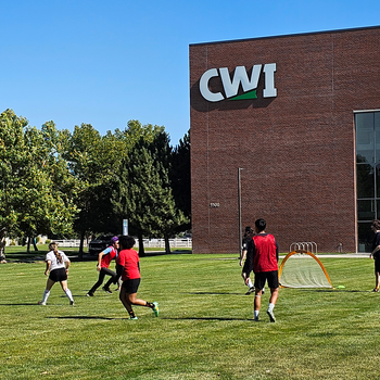 Club members playing soccer outside of the Nampa Campus Academic Building