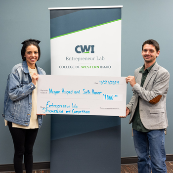 Two people hold a ceremonial check for $1000