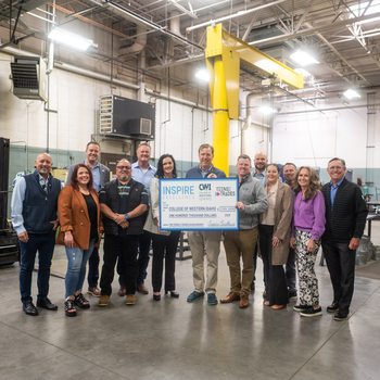 A group of 12 donors hand a ceremonial check for $100,000 to CWI President Gordon Jones.