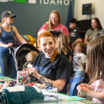 A student decorates a graduation cap at a Grad Fest.