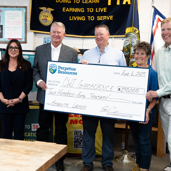 A group of people accept a ceremonial check donation for $250,000.