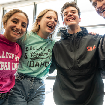 Students with arms around each other smiling and laughing
