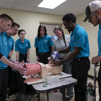 EMT students gathered mannequin practicing skills 