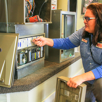 Charity Nicholson working on a HVAC repair