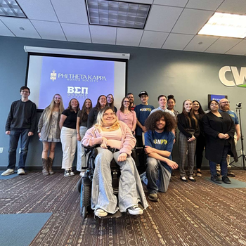 A group of students smile for a photo as they are inducted into an honors society.