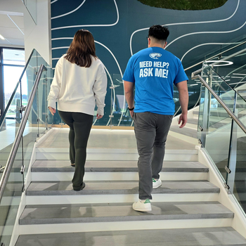 Two people walking up staircase