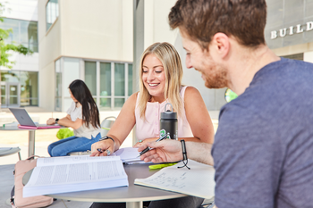 Students studying outside a campus building
