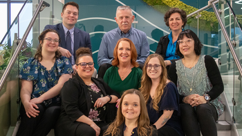 Work-Based Learning Center staff posing for a photo sitting on stairs inside a campus building
