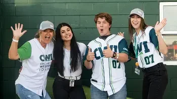 CWI employees and students posing excitedly for the camera with CWI sports jerseys on