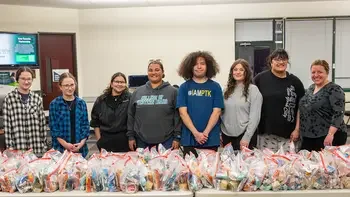 members of PTK posing in front of a table of hygiene kits they assembled